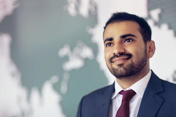 junger Manager vor Weltkarte