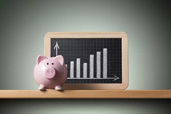Sparschwein vor kleiner Tafel mit Balkendiagramm