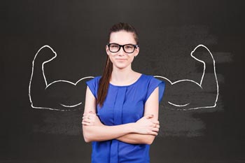 junge Frau vor Tafel mit aufgezeichneten Bizeps-Armen